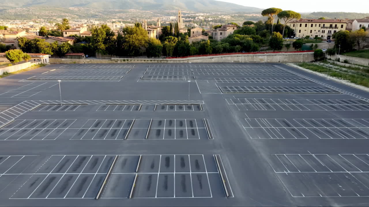 Aerial View of Large Empty Parking Lot with City in Background