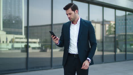 Closeup-man-taking-phone-out-of-pocket.-Businessman-celebrating-victory-outdoor