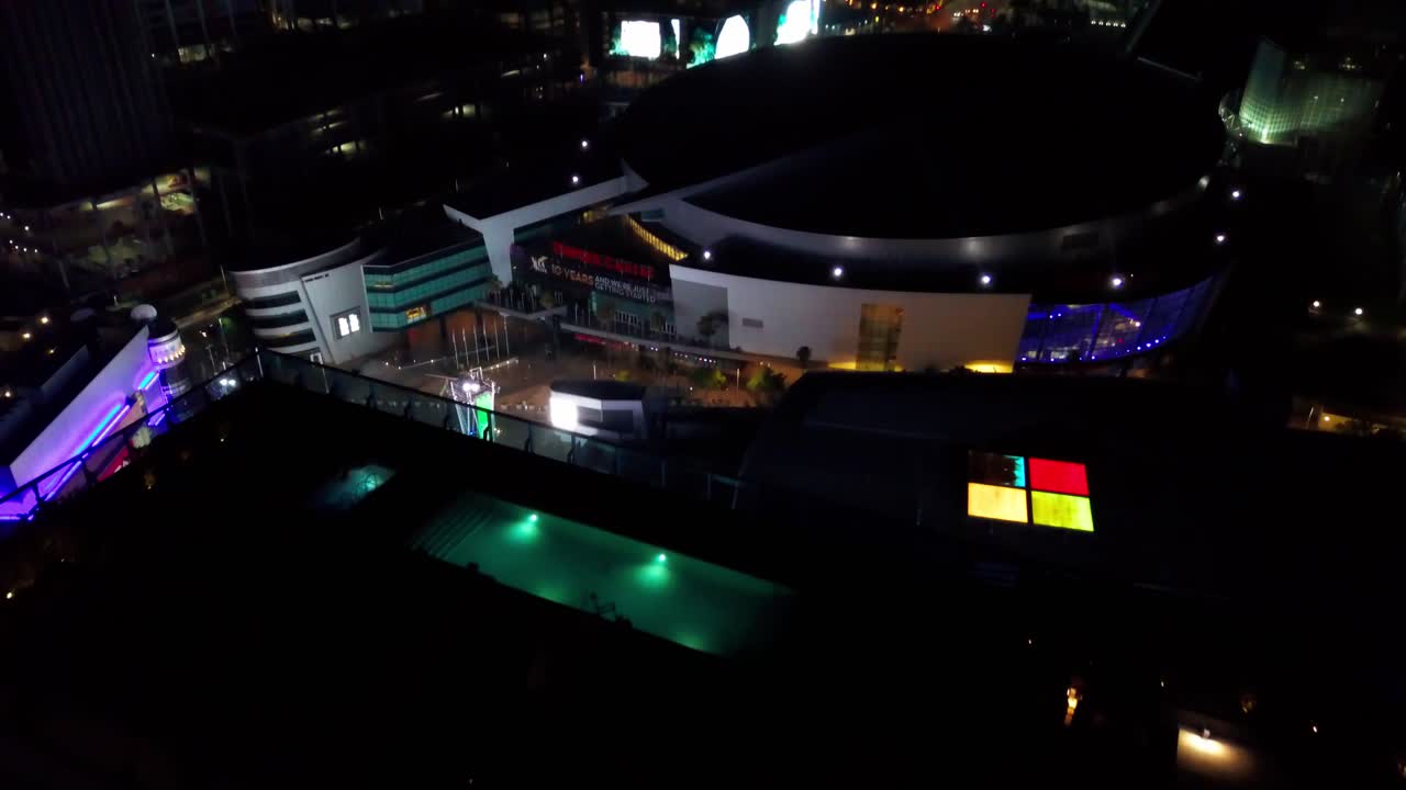Aerial flyover Downtown Los Angeles hotel to reveal Staple Center sports arena at night. 4K