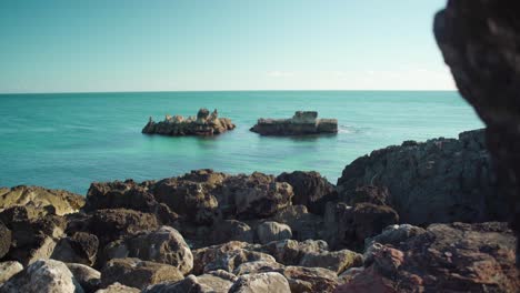 peaceful ocean view at shore with rock cliff with blue sky at cascais portugal 4k jib shot