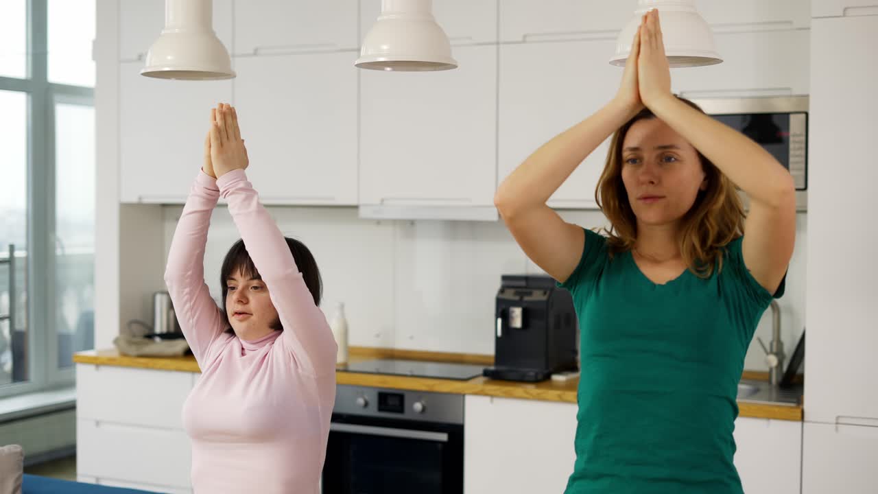 retrato de una mujer madura con una hija discapacitada practicando yoga en casa
