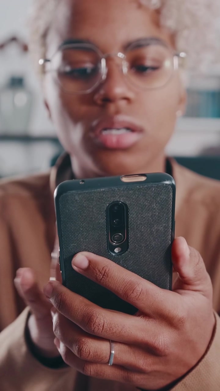 Nærbillede af afroamerikansk kvinde, der gestikulerer og taler i en smartphone-samtale