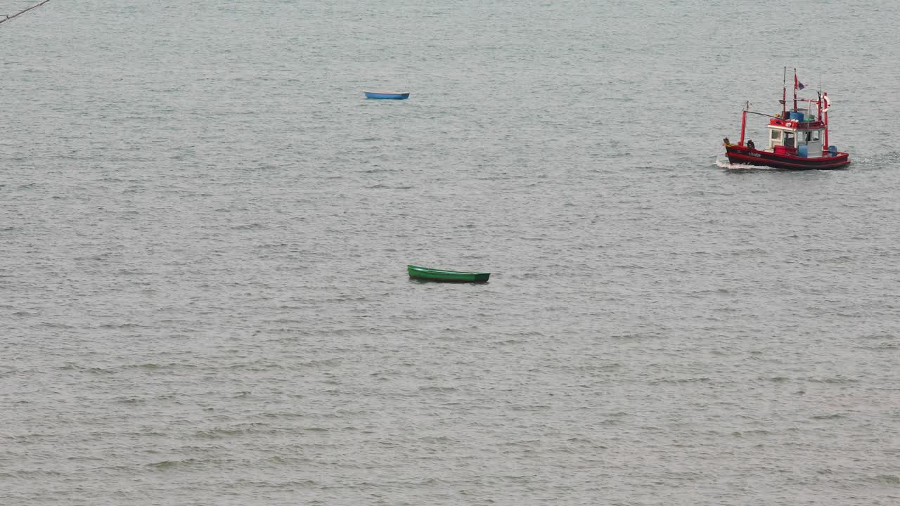 un barco pesquero tailandés rojo que navega y se detiene en las aguas de jomtien, pattaya