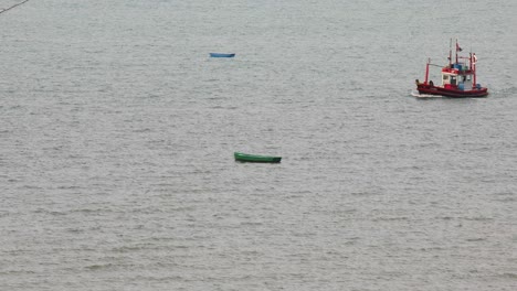 A-Red-Thai-Fishing-Vessel-Sailing-and-Stopping-in-the-Waters-of-Jomtien,-Pattaya