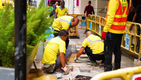 workers repairing pavement in busy urban area