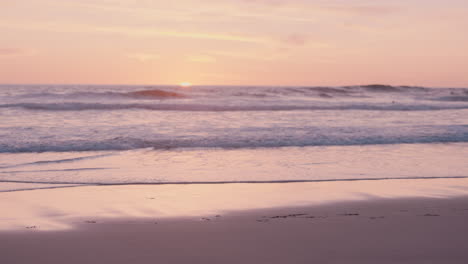 close up hand holding photograph of beautiful seaside ocean at sunset