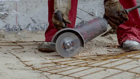 con las manos de la sierra abrasiva de corte de hierro de construcción