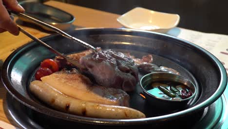 big chunks of meat cooked in korean style barbeque grill - close up shot