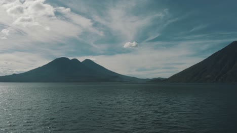 drone aerial panning over lake atitlan, 3 volcanoes in the background in guatemala