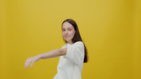 teenage girl smiling in a white t-shirt against yellow background