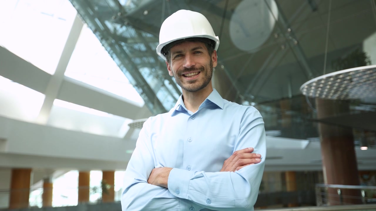 Ingeniero seguro con sombrero mirando a la cámara y sonriendo