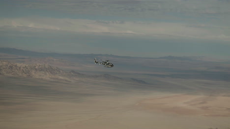 military helicopter glides smoothly through desert skies, showcasing agility during a training mission.