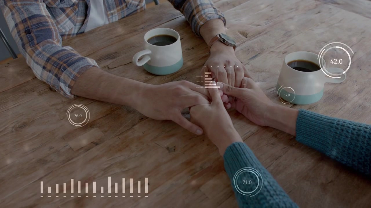 Hombre extendiendo la mano hacia las manos de una mujer sobre una mesa, con gráficos HUD tranquilos animándose alrededor de las manos, rastreando la salud.