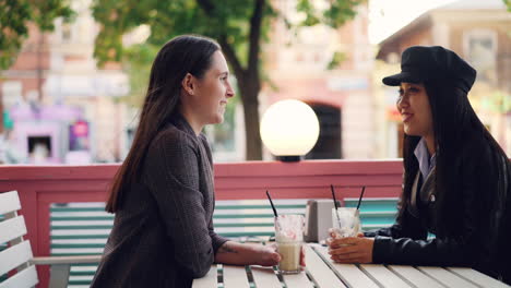two women enjoying coffee outdoors