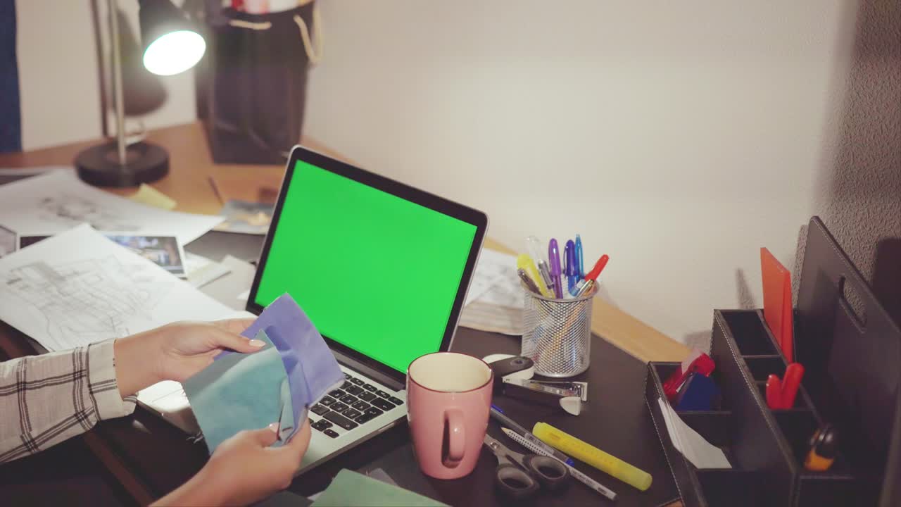 Woman working on a laptop at night in a home office