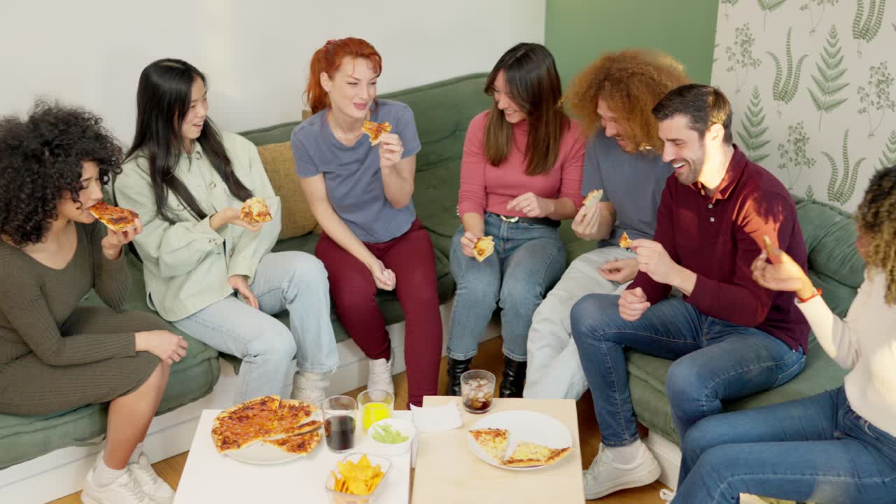 Friends eating pizza and talking at home