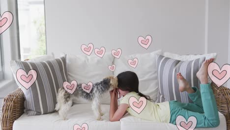 animación de corazones moviéndose sobre una niña caucásica con máscara facial jugando con su perro mascota