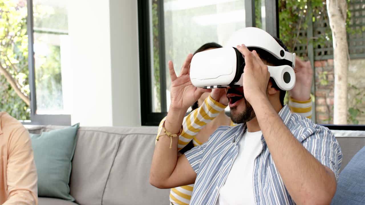 Using VR headset, man experiencing virtual reality while woman smiling behind him
