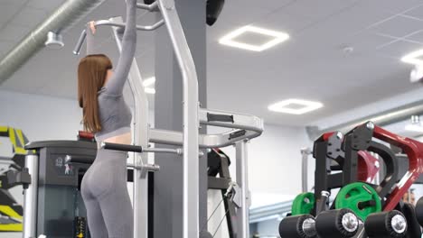 Woman doing pull-ups at the gym