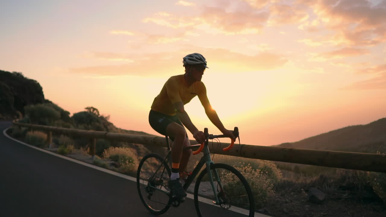 In slow motion, on a mountain serpentine, the athlete cyclist enjoys the island's view, embodying the principles of a healthy lifestyle