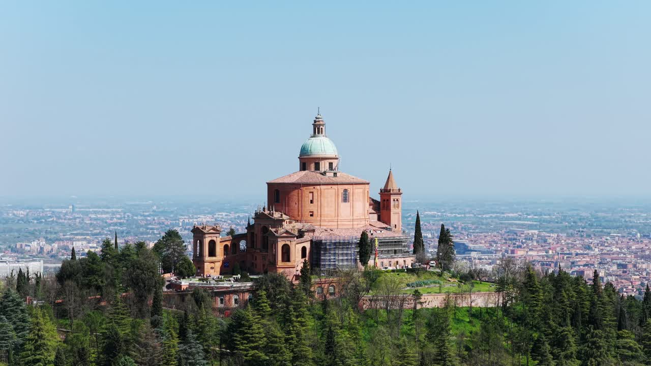 Aerial orbit of the iconic Sanctuary of San Luca in Bologna, Italy, surrounded by lush hills and overlooking the sprawling cityscape. travel and heritage themes