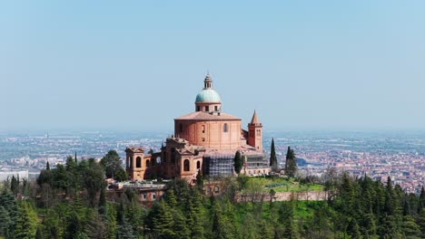 aerial orbit of the iconic sanctuary of san luca in bologna, italy, surrounded by lush hills and overlooking the sprawling cityscape. travel and heritage themes