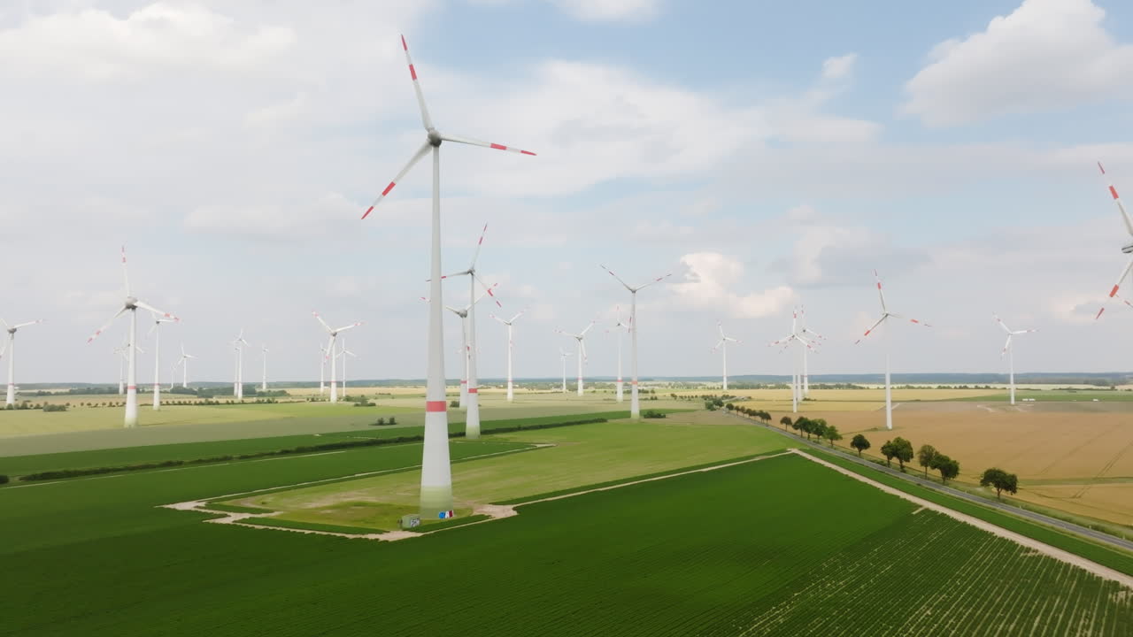 Aerial wide shot of many wind power generators on the countryside, summer day