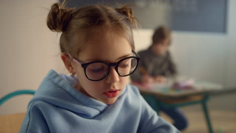 schoolgirl talking at lesson in classroom. pretty girl posing at camera