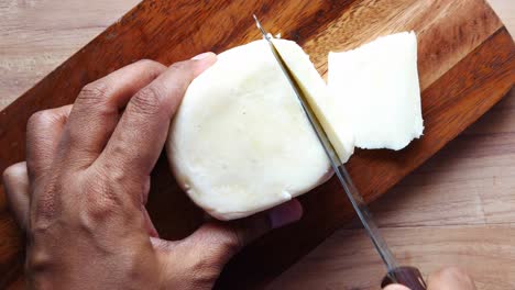 cutting a block of white cheese