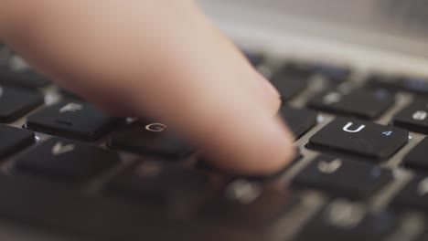 close-up of a finger pressing the enter key on a laptop keyboard, blurred background