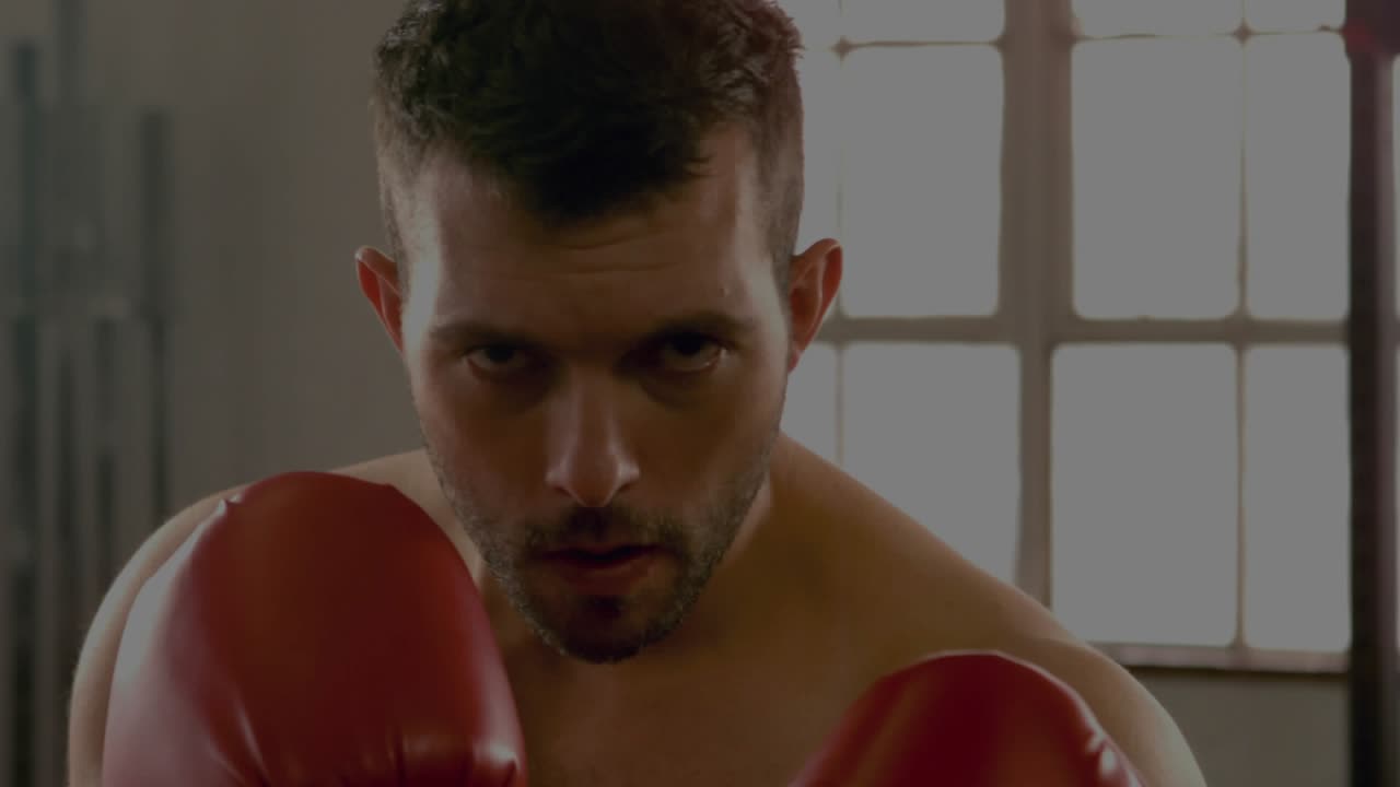 Male boxer making eye contact and launching quick jabs at camera, red gloves flashing, lens flares
