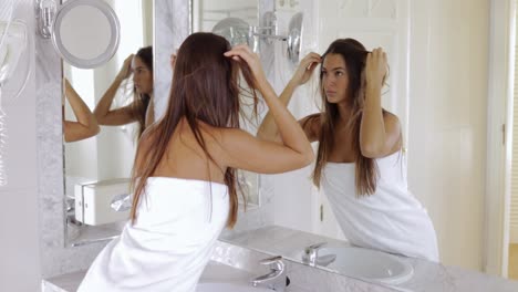 young woman admiring reflection in mirror