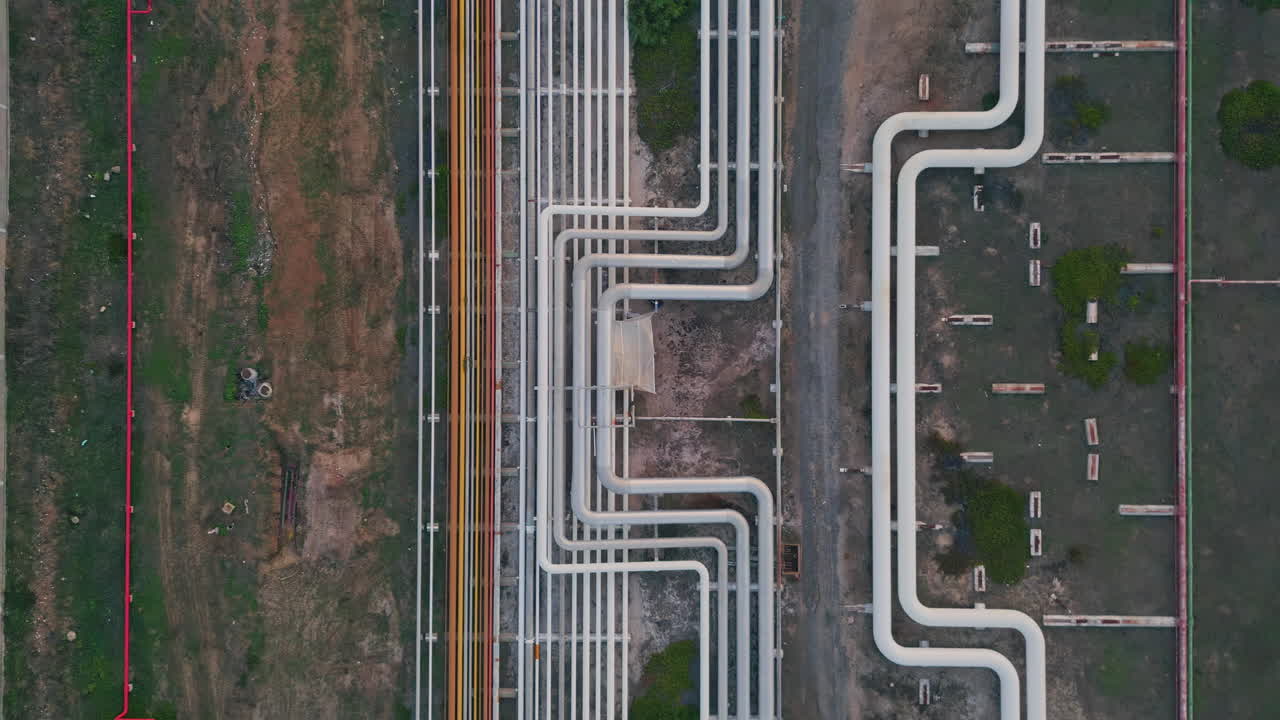 Pipelines transporting oil fuel at industrial facility. Drone view gas terminal