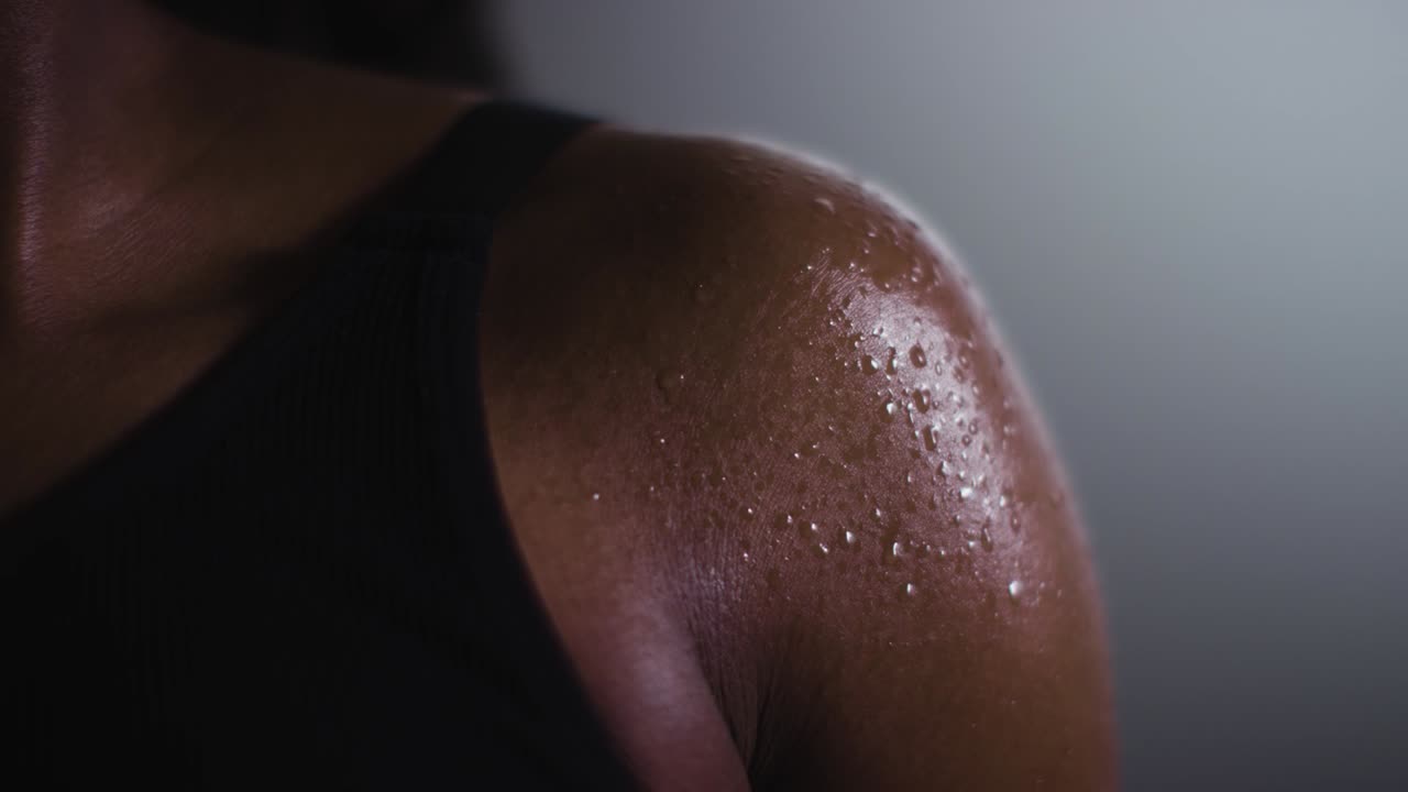 disparo de cerca de perlas de sudor en una mujer que usa ropa de gimnasia haciendo ejercicio 4