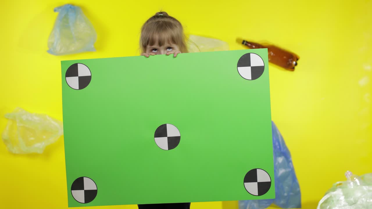 Ragazza attivista che tiene un poster chroma key con punti di tracciamento. Inquinamento ambientale da plastica e rifiuti