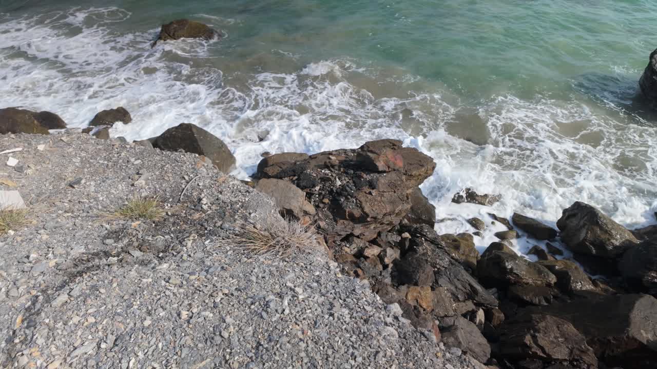Rocky beach with crashing waves, a serene nature scene with the ocean's gentle rhythm