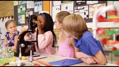 Niños-De-Escuela-Mirando-A-Través-Del-Microscopio-En-El-Laboratorio