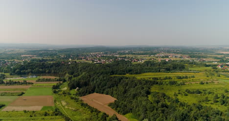 Aerial-View-Of-Landscape-And-Small-City-Agains-Mountains