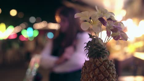 pineapple-decoration-with-orchids-against-blurry-tourists