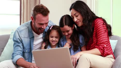 Familia-Feliz-Usando-Una-Computadora-Portátil-En-El-Sofá