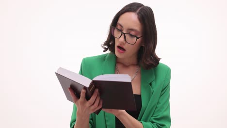 woman in green blazer and glasses reading a book
