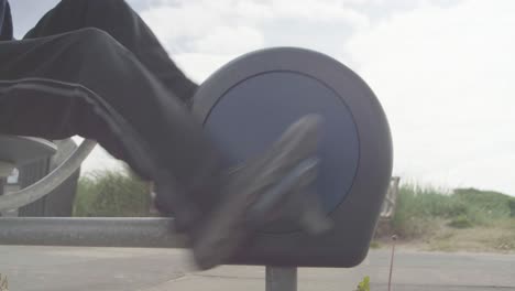 an adult’s legs and feet exercising on an exercise bike at the beach