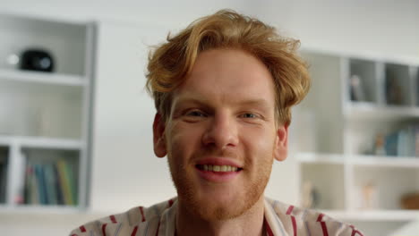 Closeup-positive-guy-chatting-online-with-family.-Smiling-ginger-man-nodding
