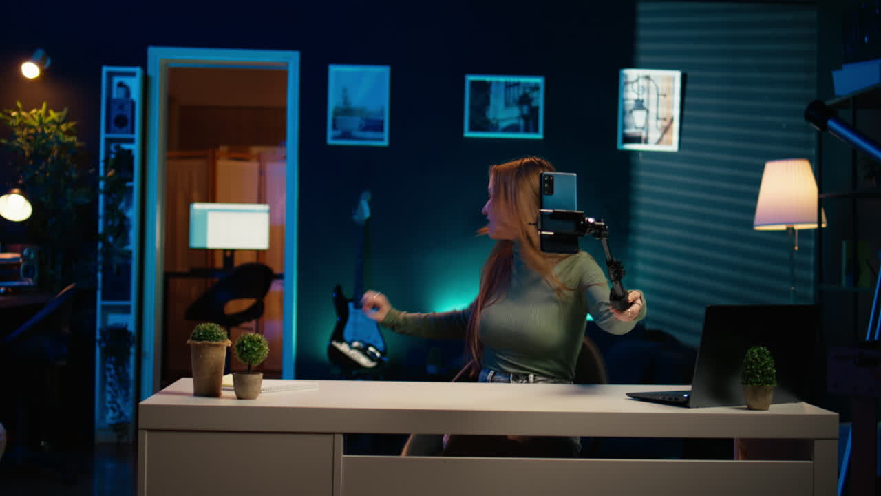 셀피 스틱을 이용해 블로그 소개를 찍는 네온 조명 아파트의 소녀