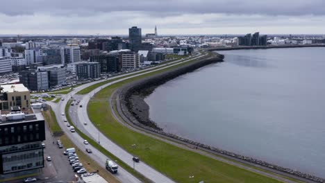 shoreline of reykjavik skyline in iceland, shore walk path and hofdi lighthouse