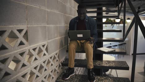 hombre con computadora portátil en las escaleras de la oficina