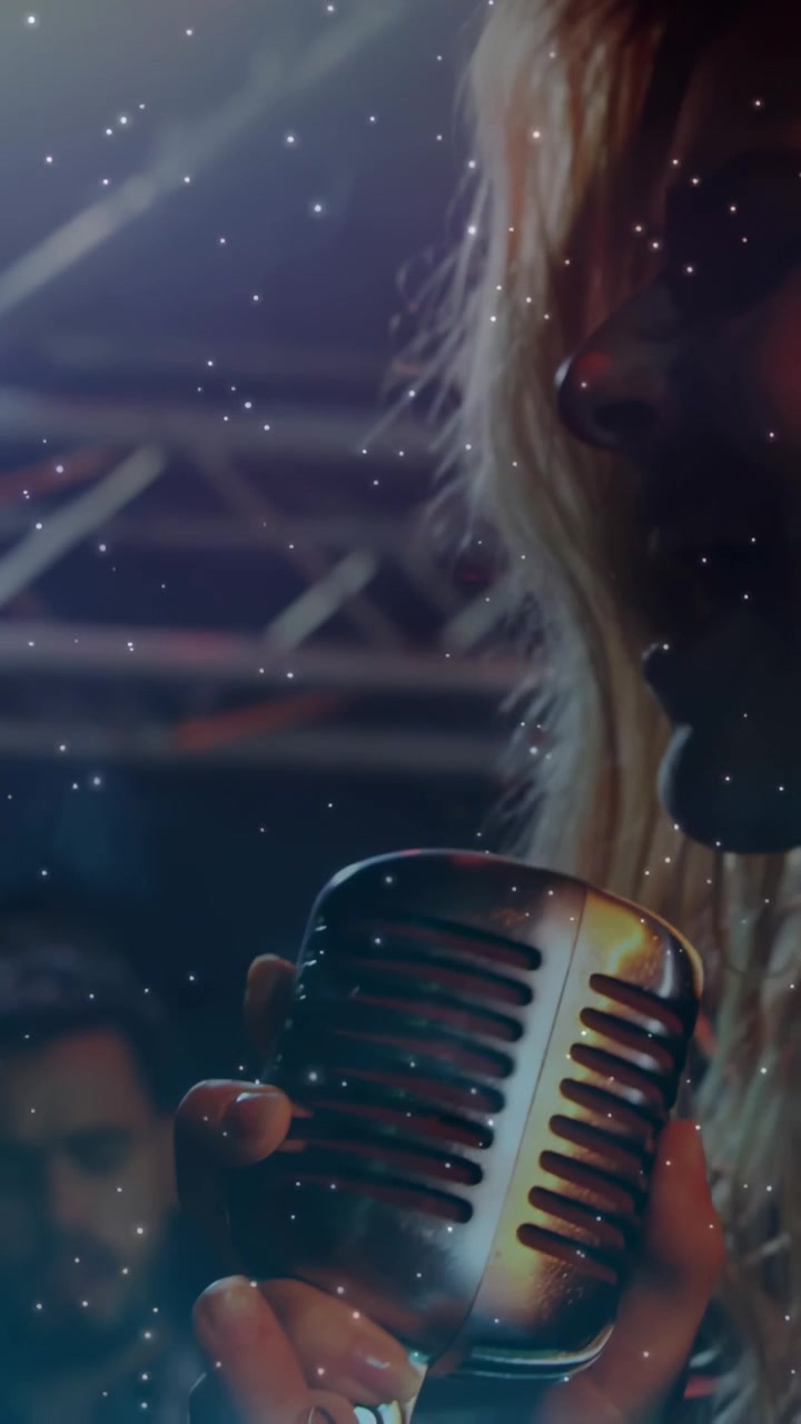 Vertical video: Singer starting singing into mic camera receding stars drifting over face emoting
