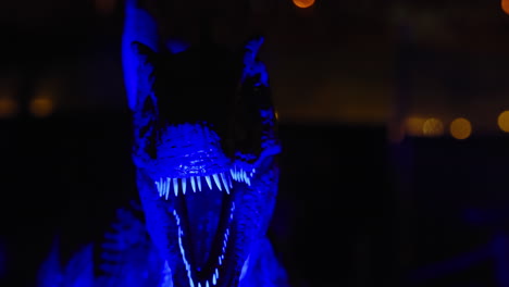 cierre el dinosaurio t-rex iluminado moviéndose en un parque temático infantil