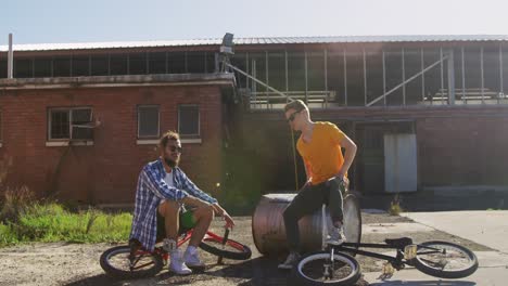 bmx riders sitting in a yard talking