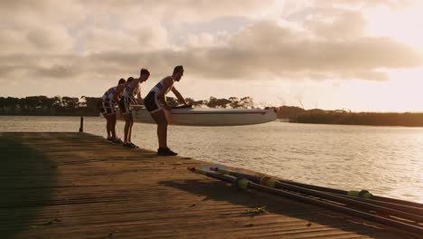 equipo de remo masculino aterrizando el bote en el lago